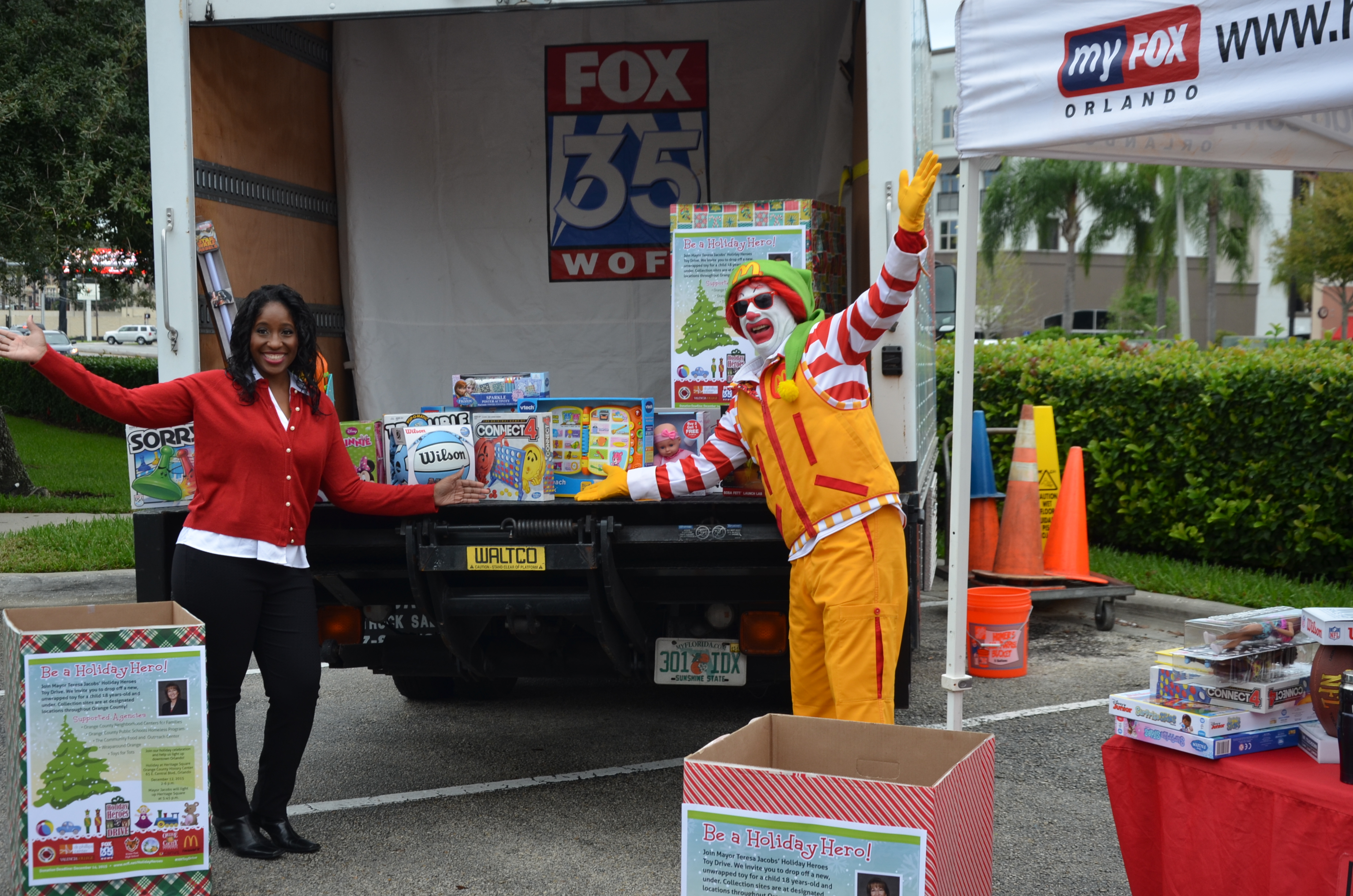 Ronald McDonald y un representante de Good Day Orlando con juguetes para la colecta