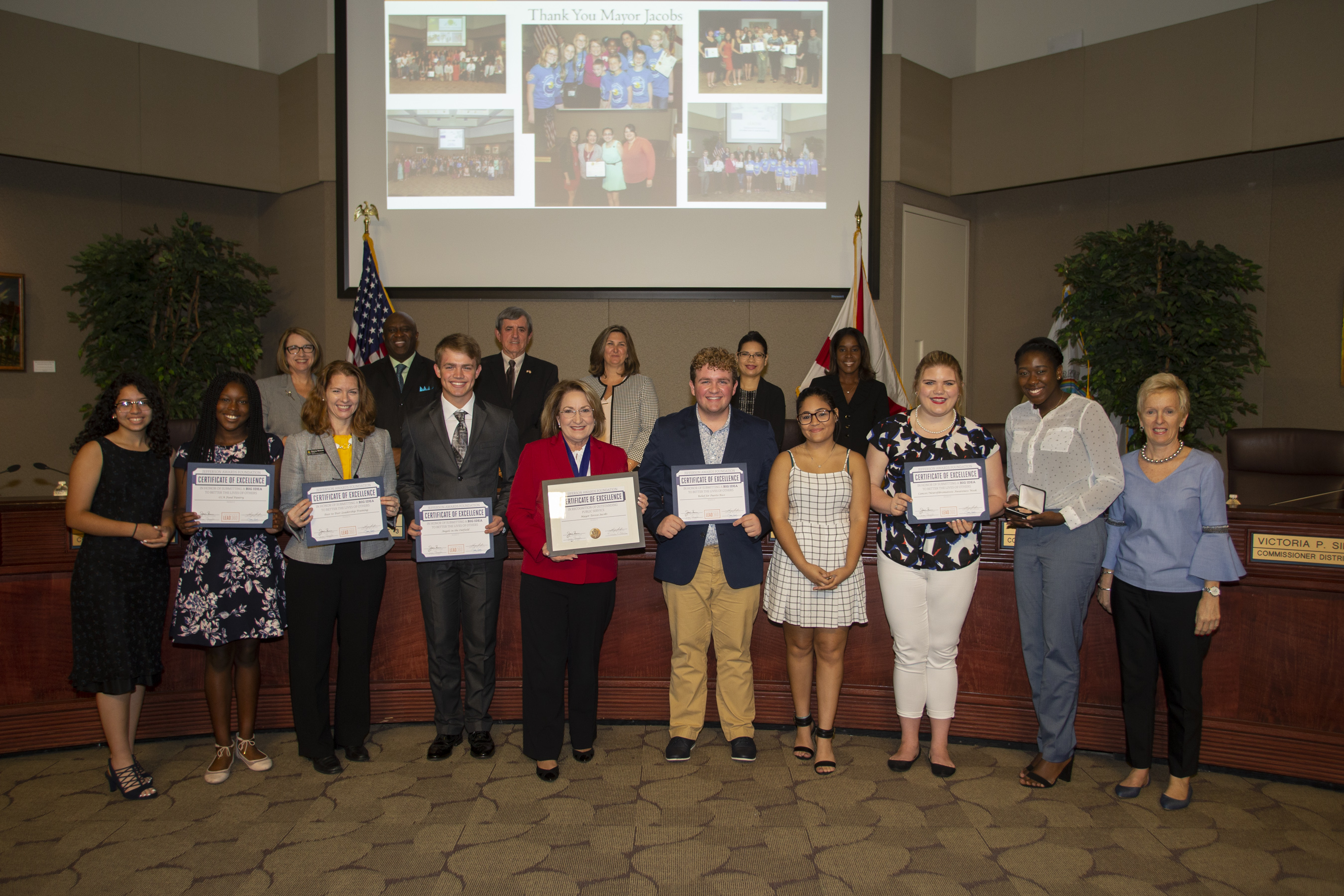 People standing with award certificates in hand