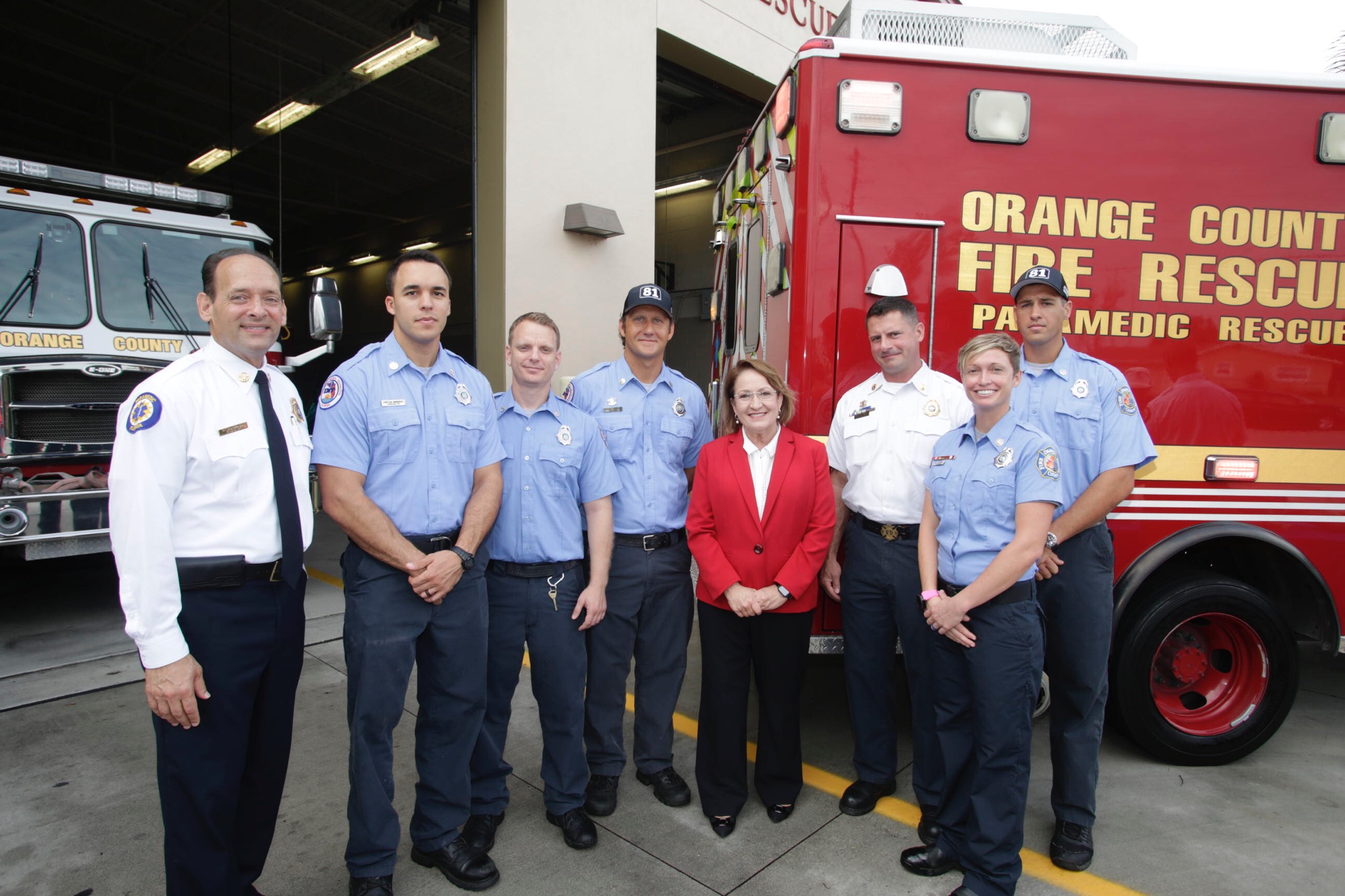 Mayor Jacobs, Chief Drozd, and some first responders stand for a picture at a fire station