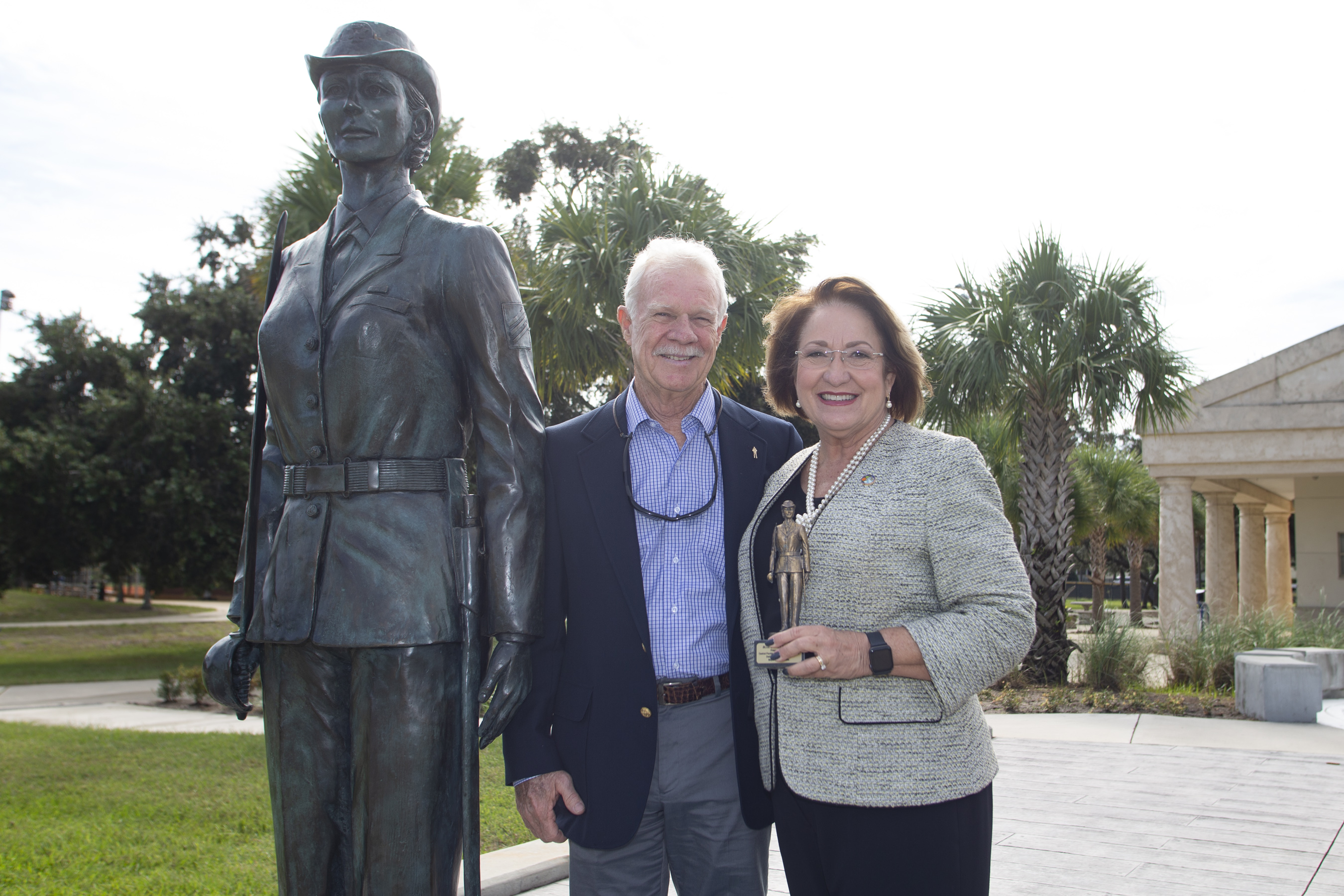 La Alcaldesa Jacobs y un hombre parados junto a una estatua