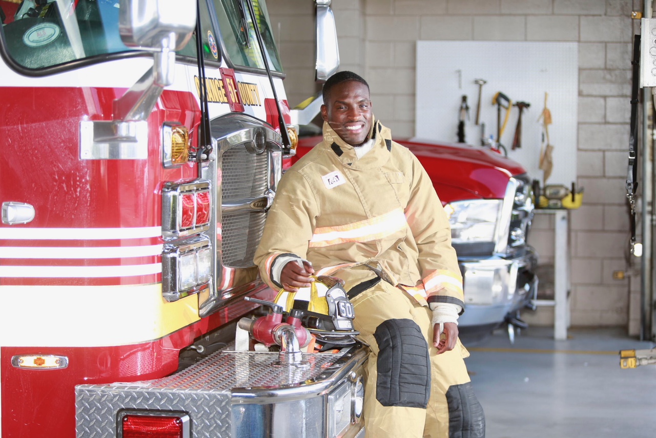 Firefighter Steve O leaning on a fire truck inside the station