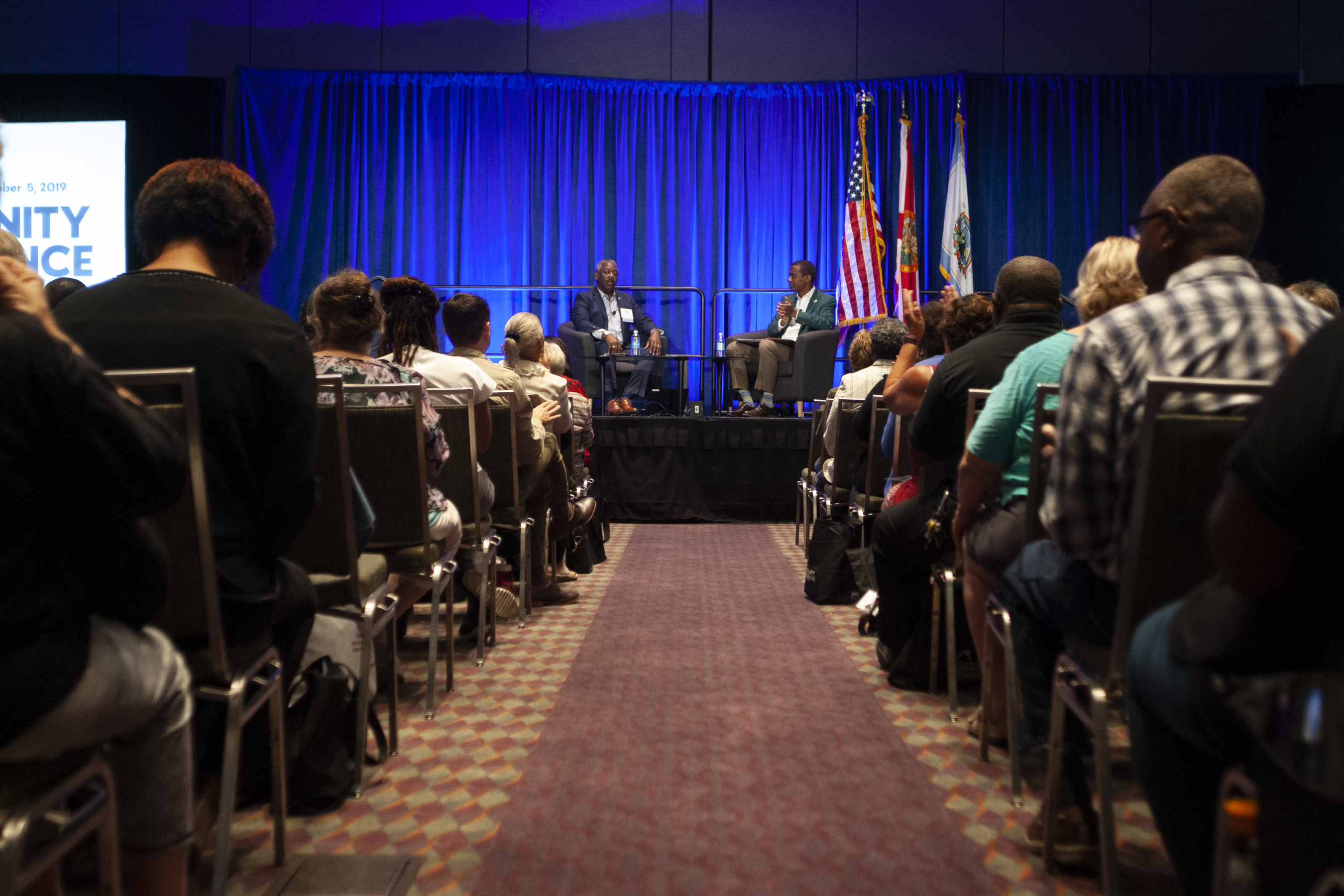 Mayor Demings and Jason Reynolds sitting on chairs on stage as the crowd attentively listens to their discussion