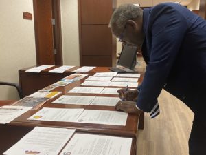 Mayor demings over a table signing documents