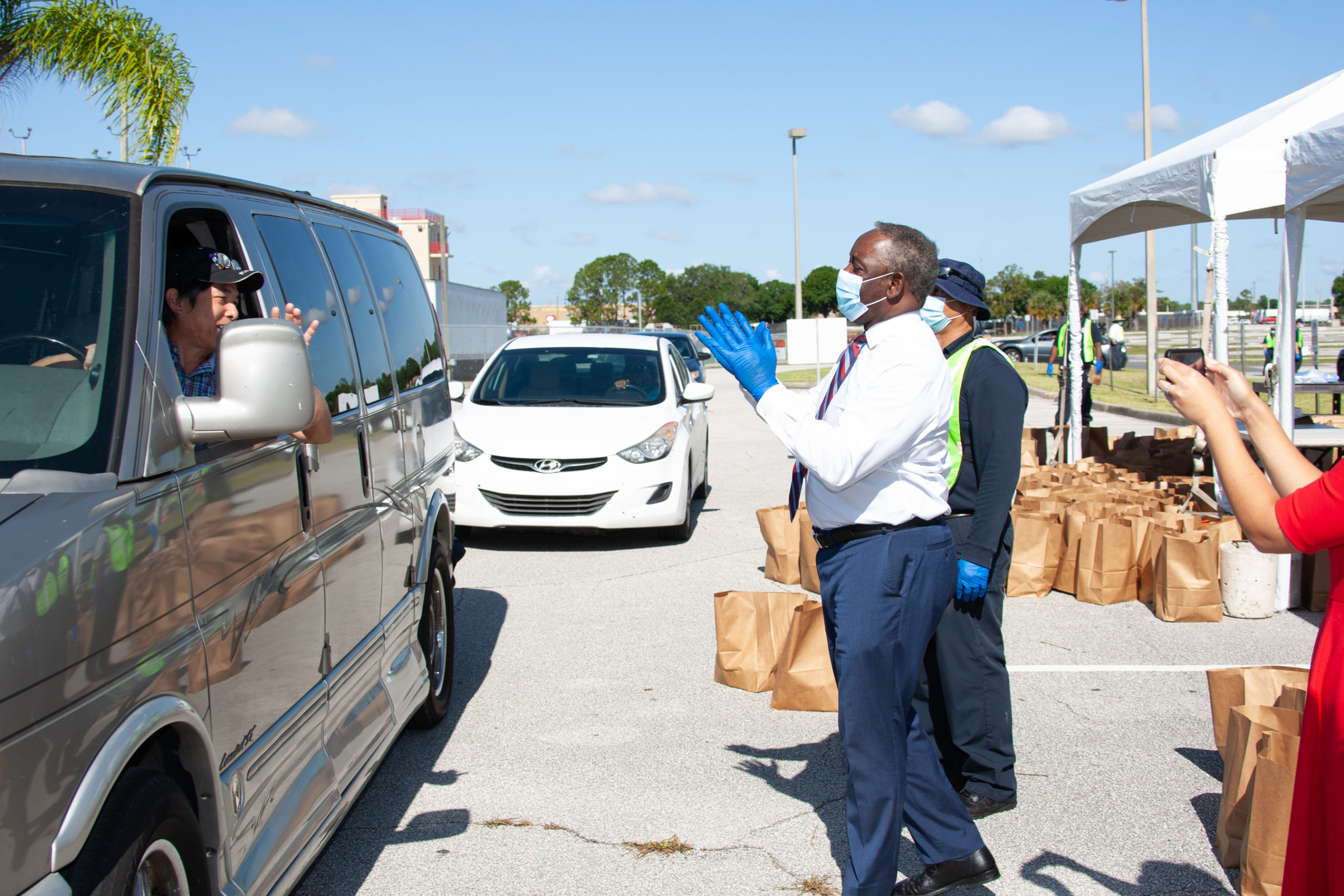 El Alcalde Demings entrega suministros a un conductor que pasa por el sitio de distribución