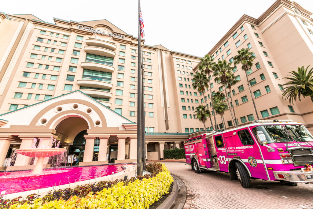 Camión de bomberos de color rosa estacionado afuera de un edificio